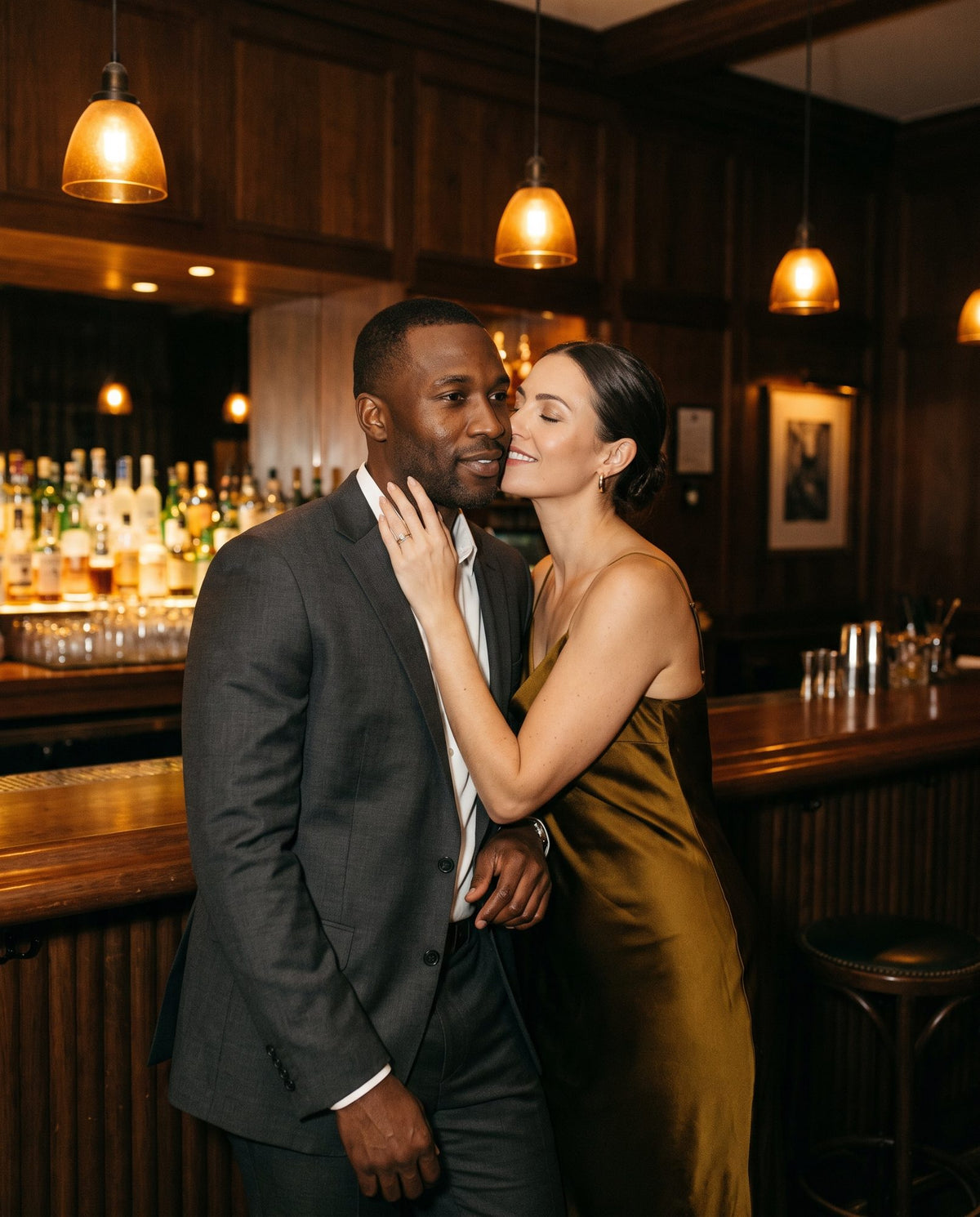 A woman leans in to smell a man's neck at a hotel bar